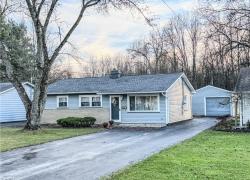 Single story home with a front yard and a garage